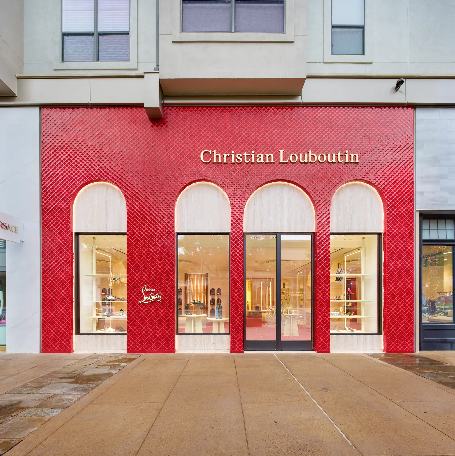 Red façade and arched windows of the Christian Louboutin boutique at The Domain in Austin