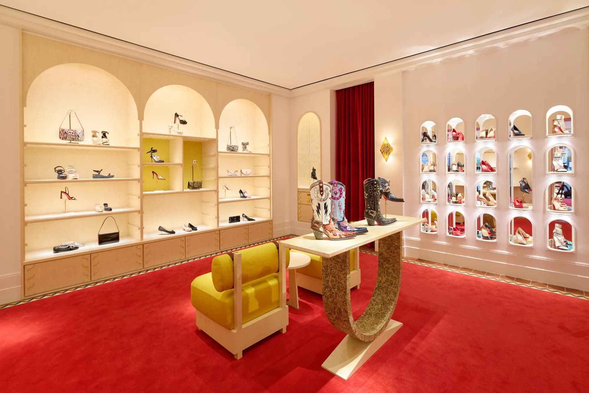 Shoe salon with arched shelving, a gold chair and a wall of shoe niches