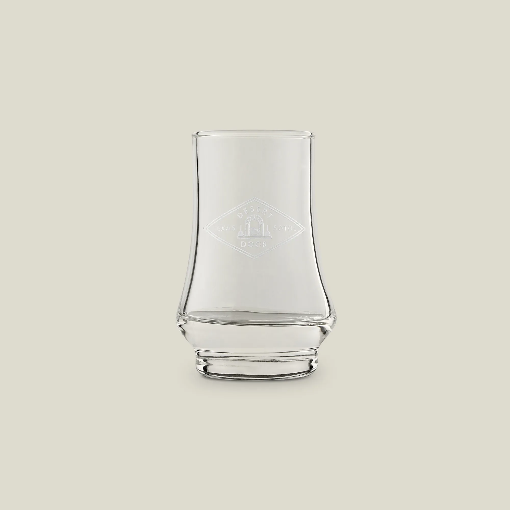 Glencairn glass of clear sotol on a neutral background