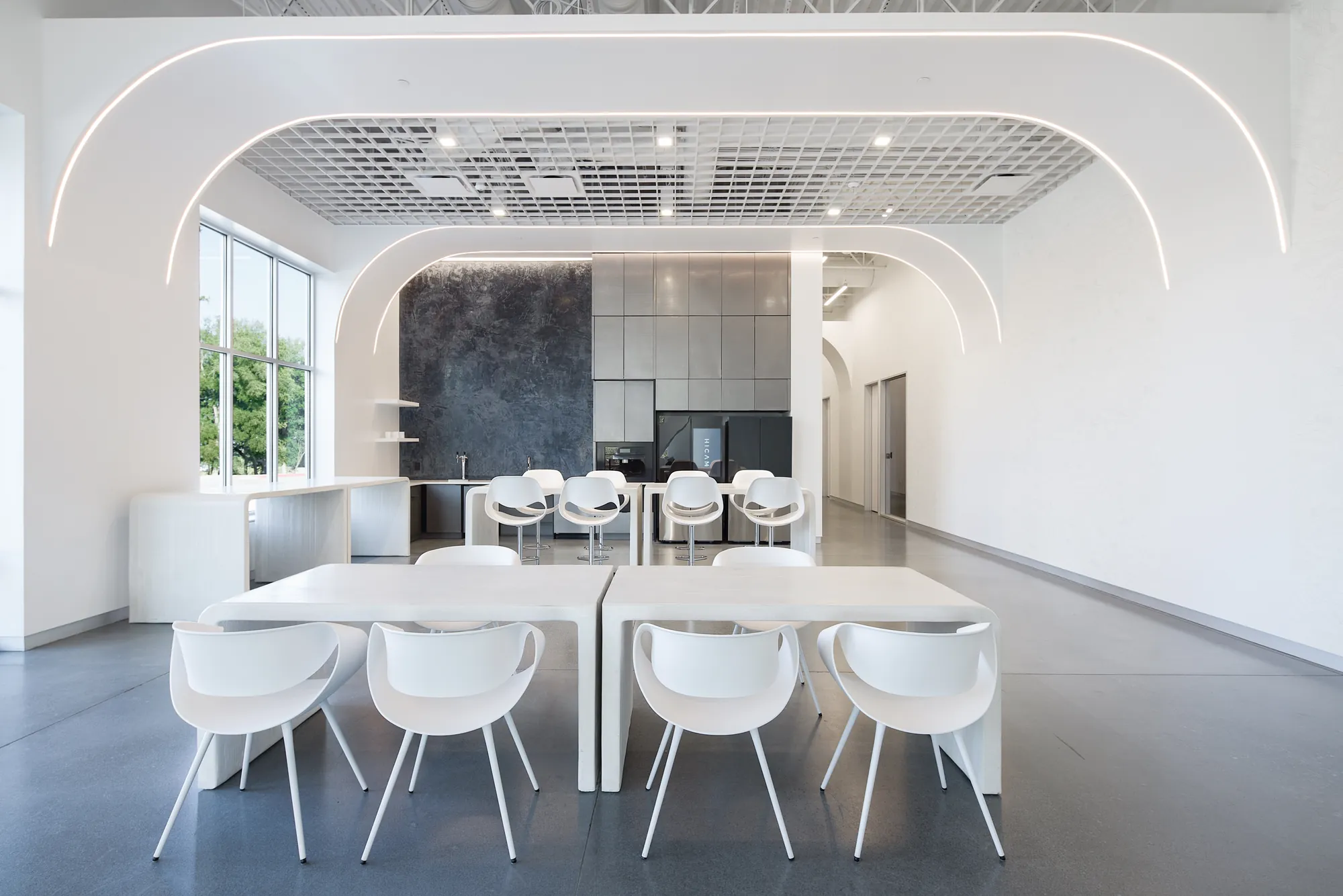White break room with sculpted arches and dining tables