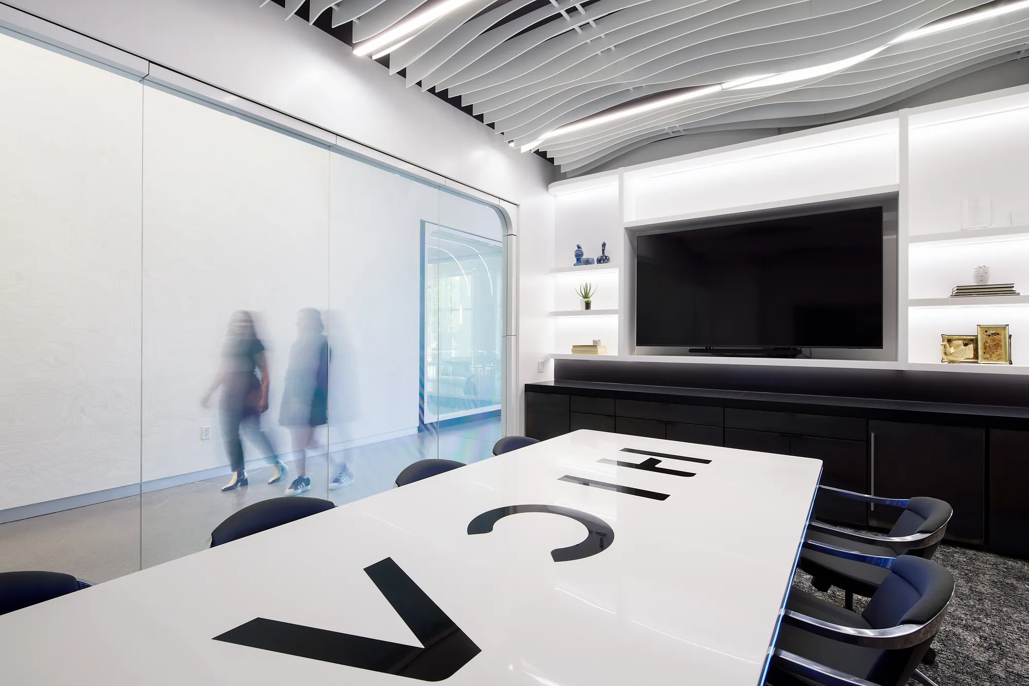 Conference room with HICAM lettering on the table and motion-blurred people