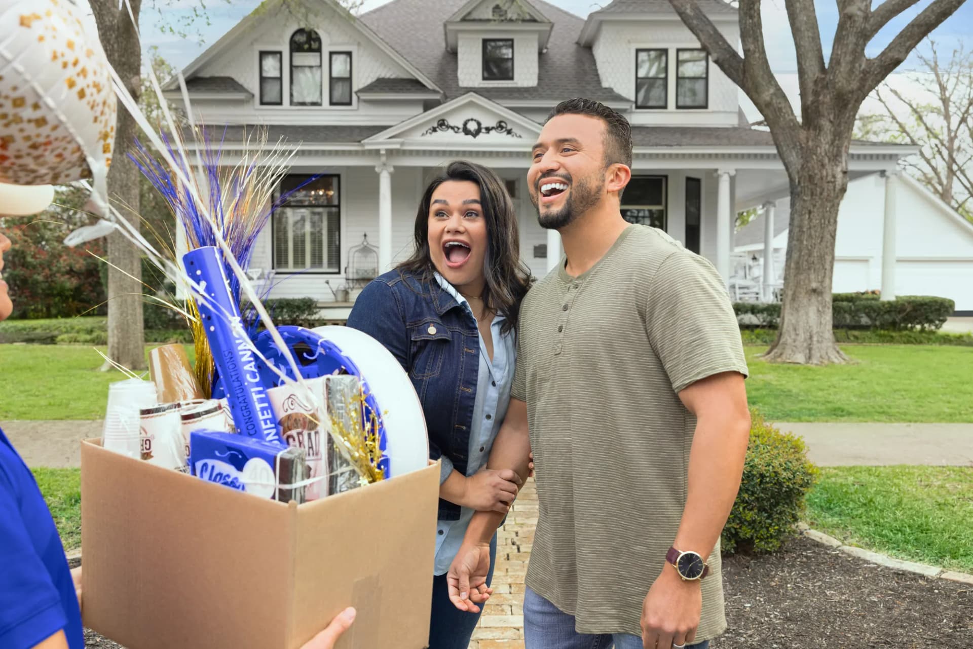 Parents surprised by a graduation gift box on the front lawn