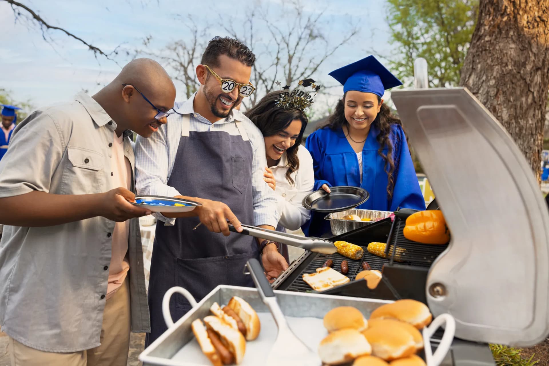 Family grilling burgers at a backyard graduation party