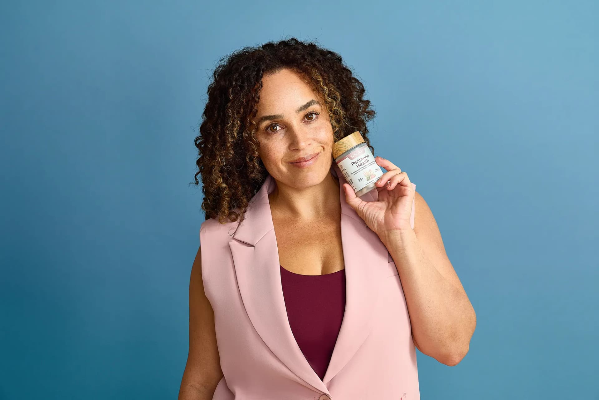 Model in a pink vest holding a SNAP Supplements bottle