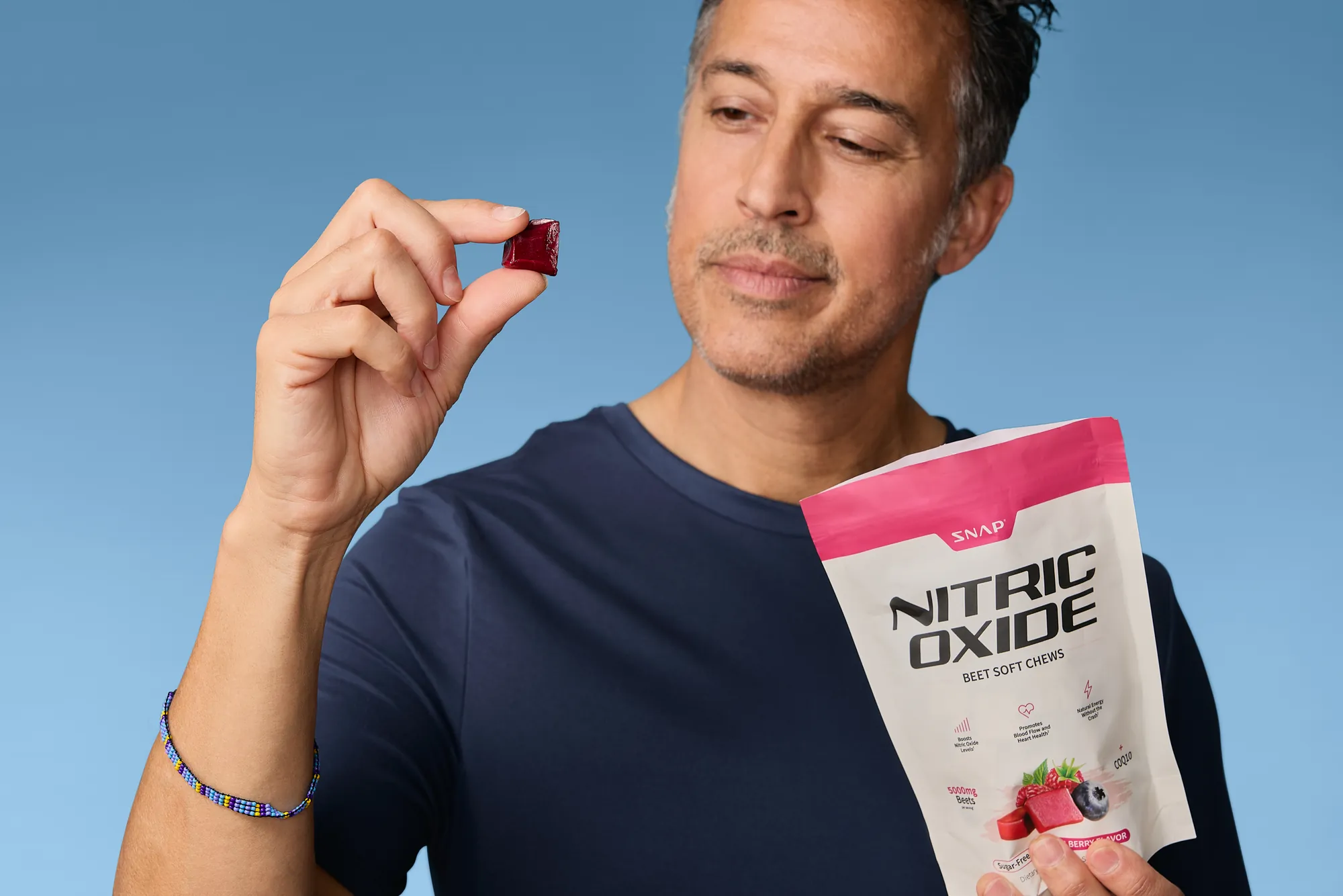 Model holding a soft chew beside a SNAP Supplements pouch
