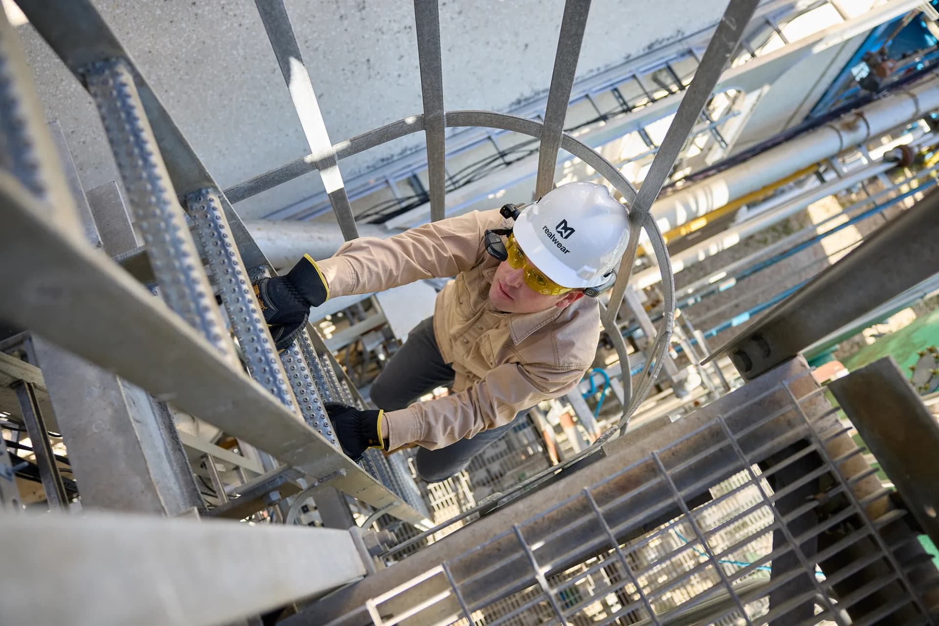 Worker climbing industrial scaffolding