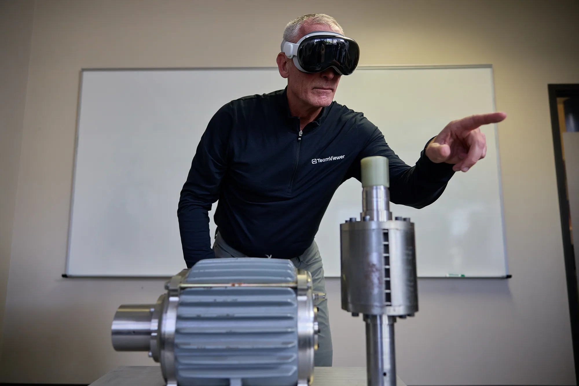 Presenter wearing a mixed-reality headset beside industrial equipment