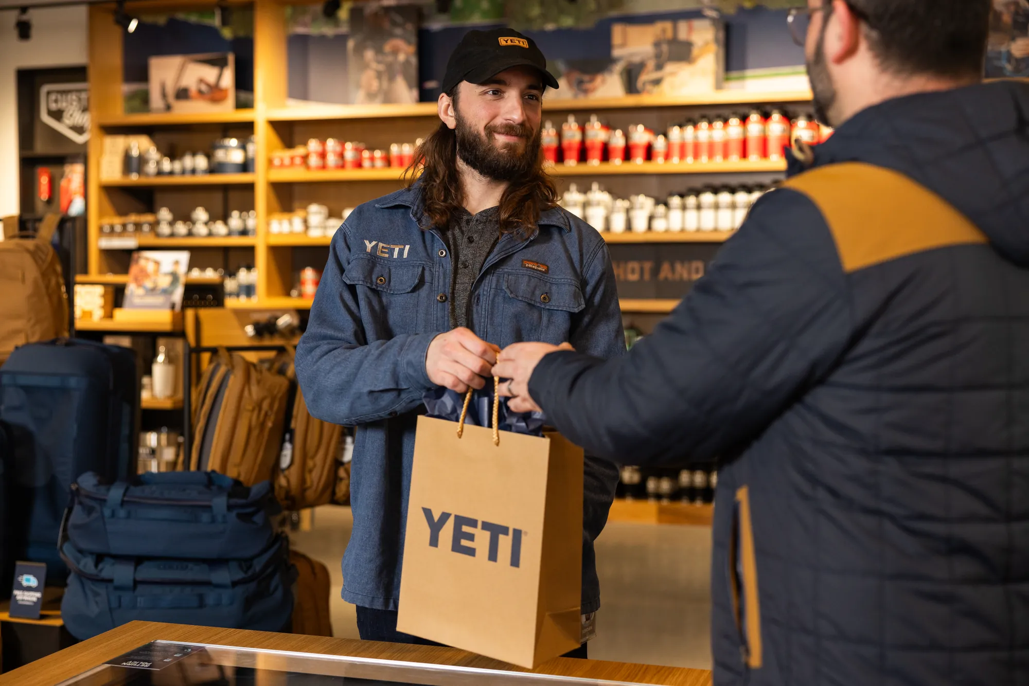 YETI store associate handing a customer a shopping bag