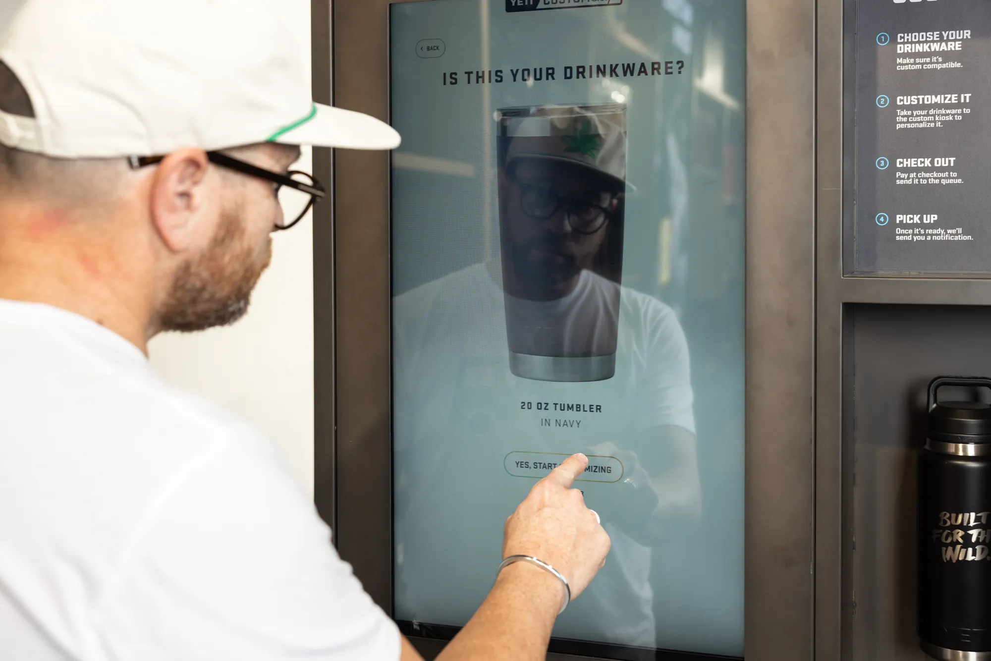 Customer browsing a digital display inside the YETI store