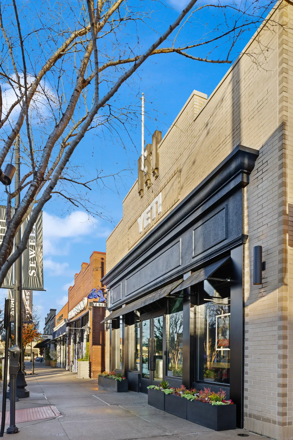 YETI storefront along a tree-lined sidewalk